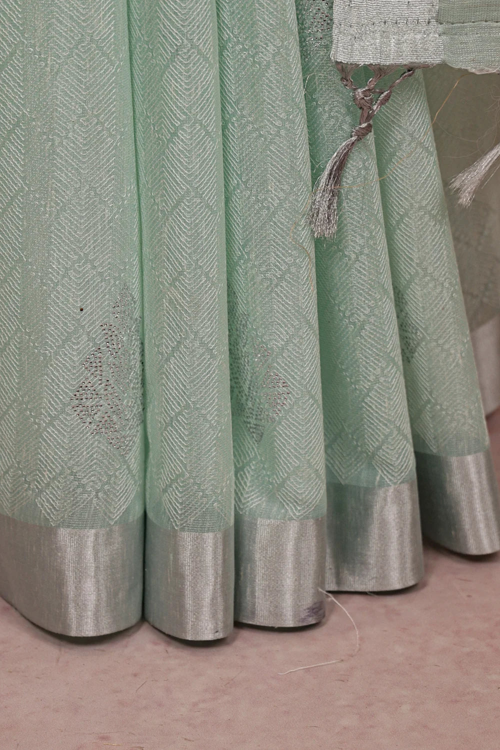 Sea Green Semi Tissue Saree fabric spread, silver border and stone work detail