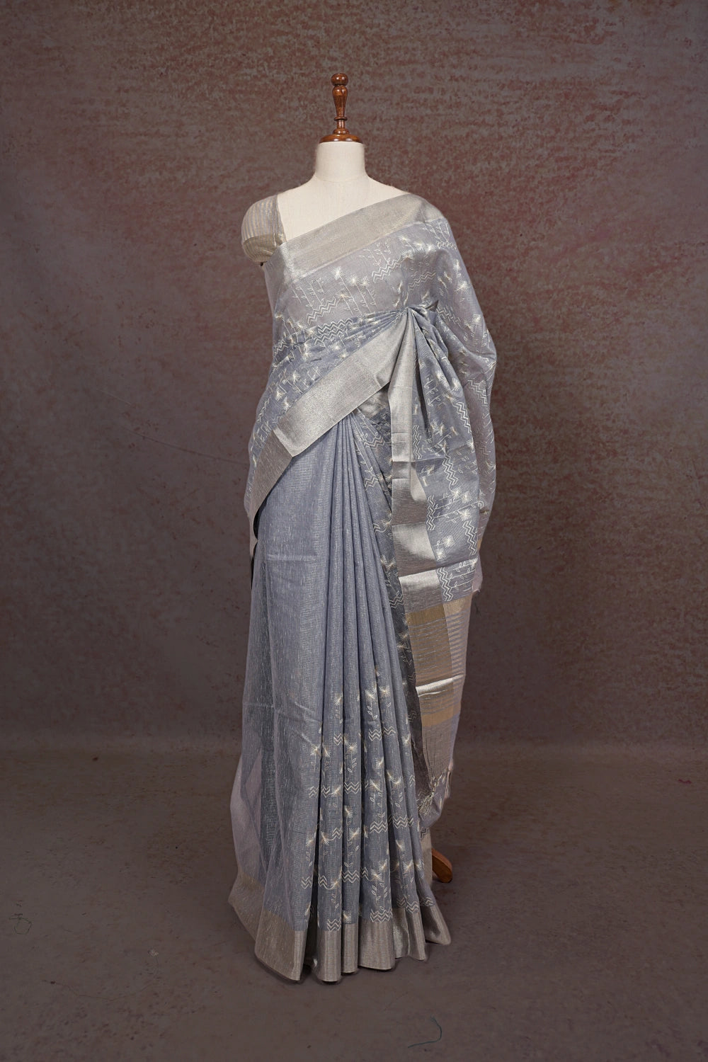 Ash grey kota saree with silver thread work and matching silver border, draped on mannequin - Seematti