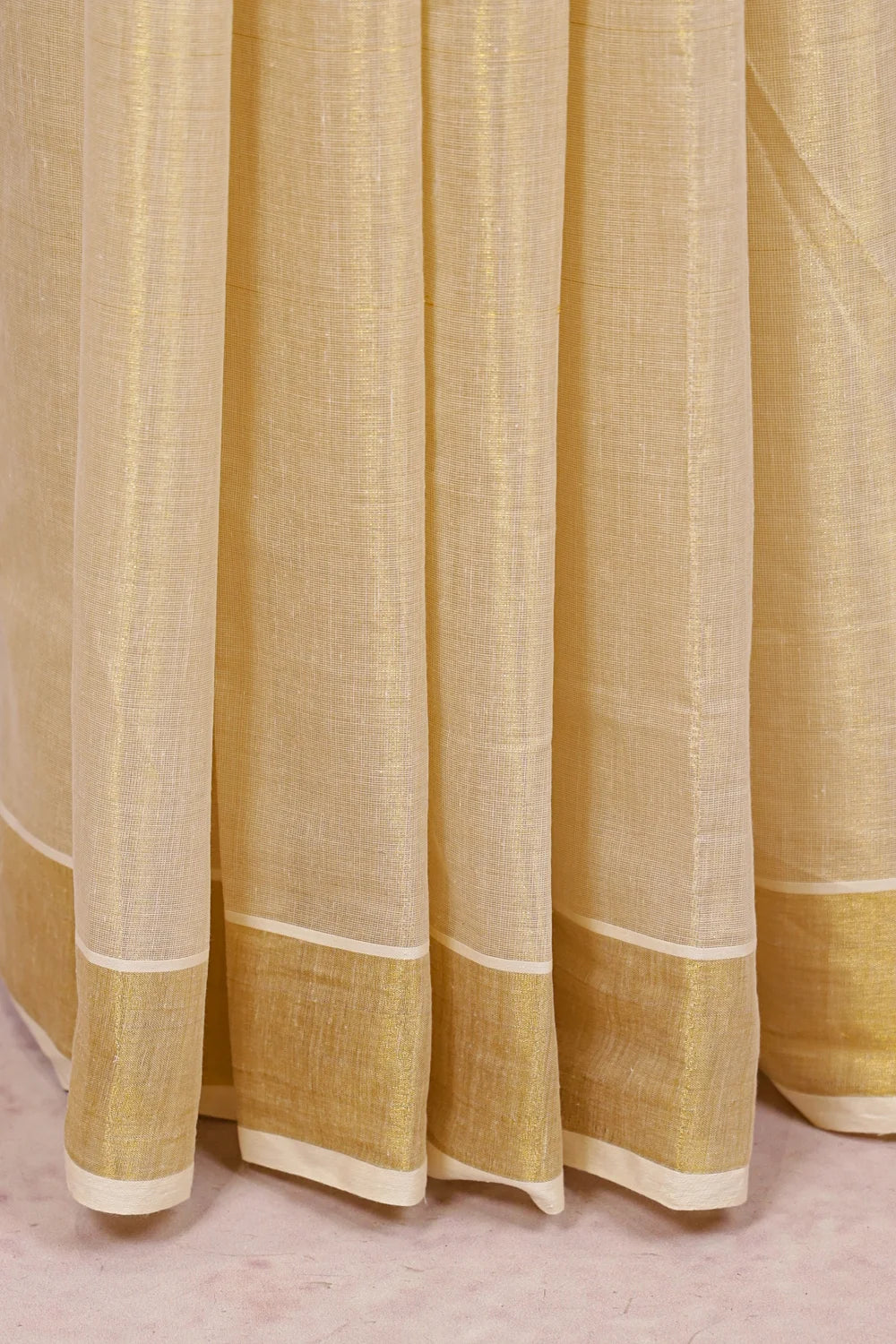 Cream tissue Kerala saree fabric texture with golden stripe