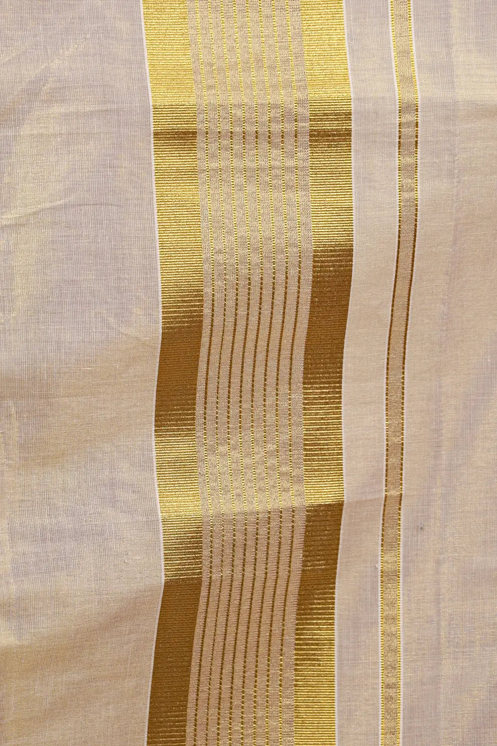 Cream tissue Kerala saree fabric spread showing Kasavu border