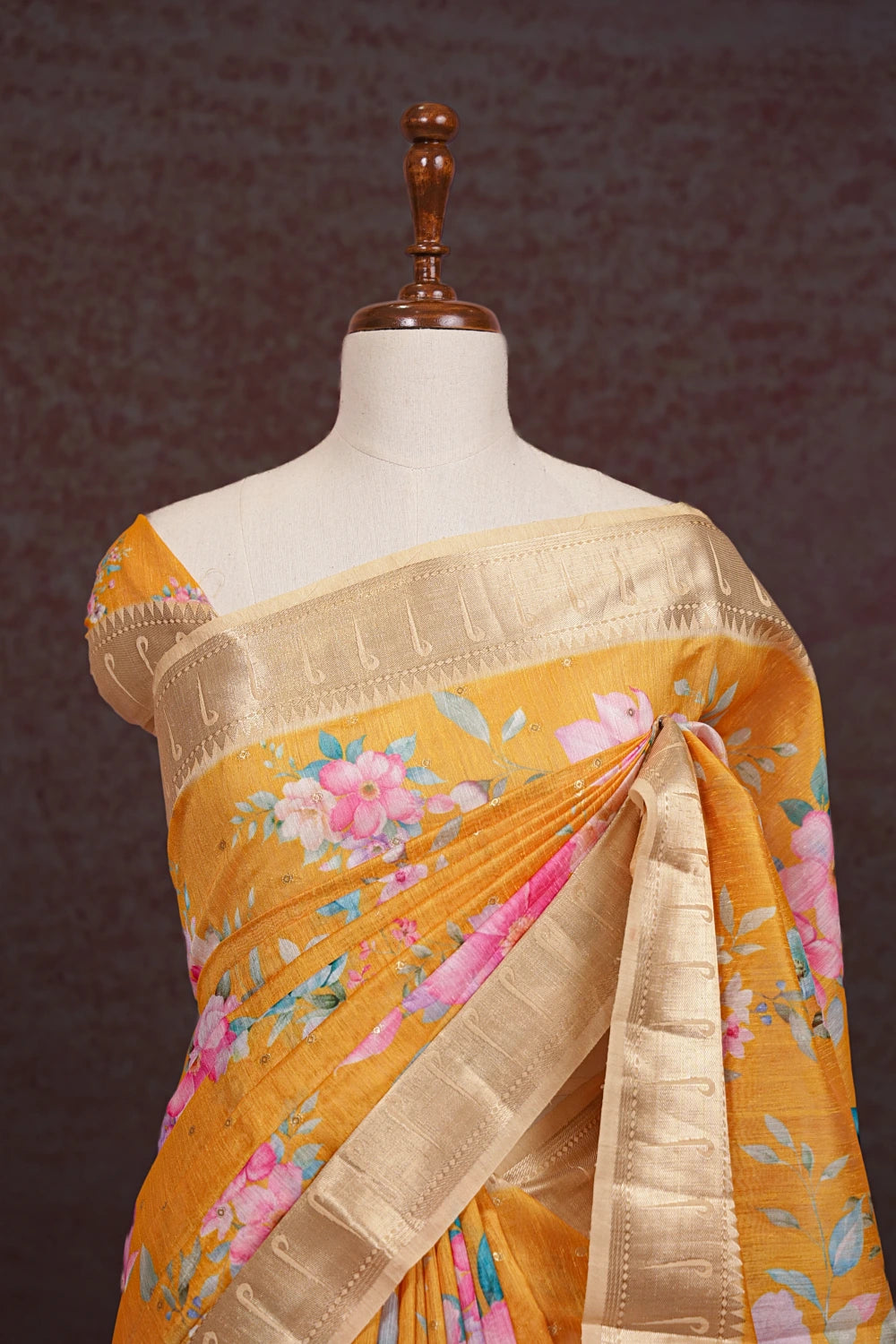 Orange jute saree pallu close-up with gold border