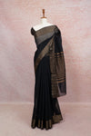 Black semi jute saree with plain body and gold zari border draped on mannequin