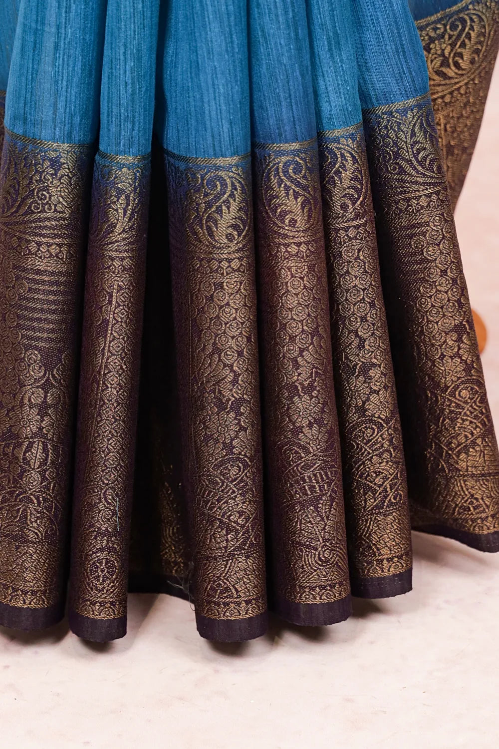 Blue semi jute saree fabric spread, paisley zari border
