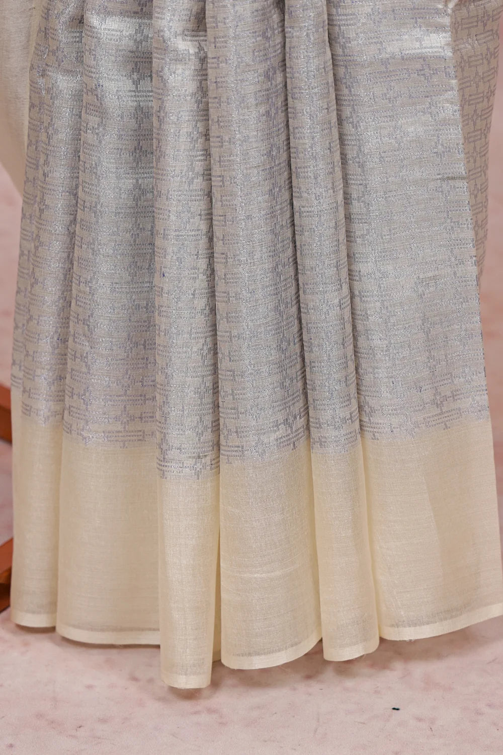 Silver tussar silk saree fabric spread, textured weave with cream border