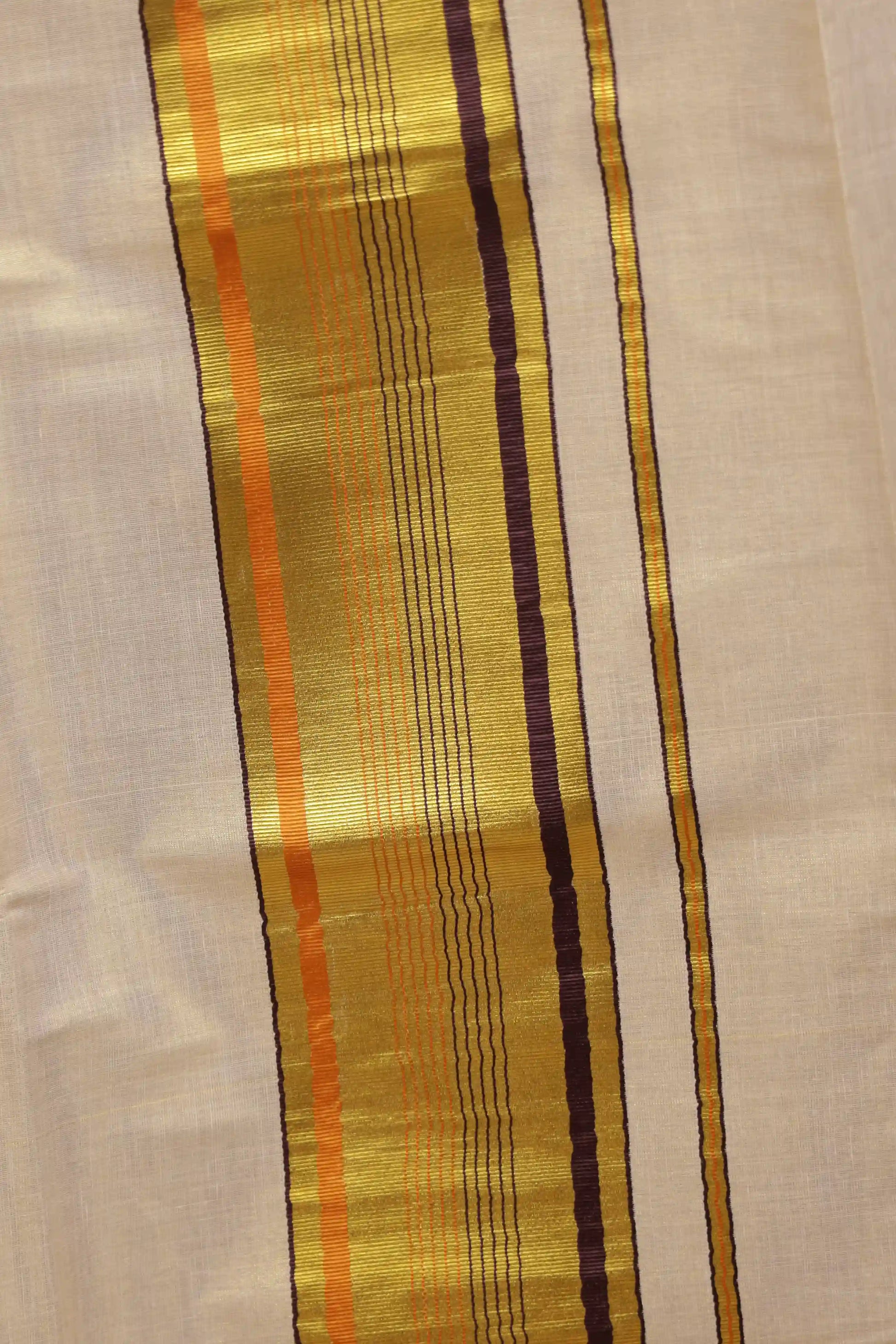 Golden tissue Kerala saree fabric spread, wide temple border