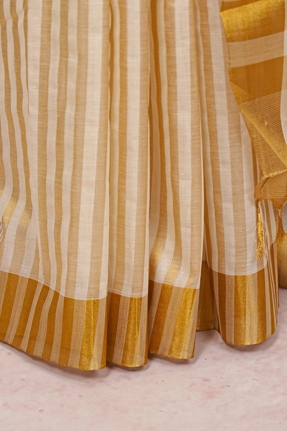 Off White Cotton Kerala Saree fabric spread, golden striped border detail