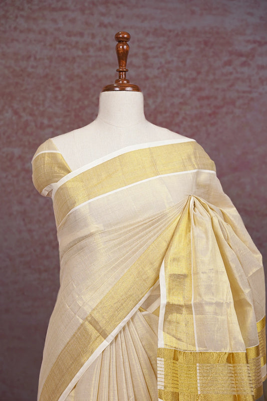 Cream Kerala saree pallu close-up with gold border detail